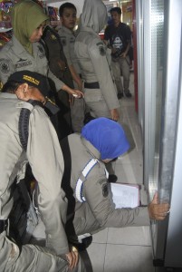 MENGECEK. Satpol PP memastikan penjualan minuman beralkohol di sejumlah minimarket di Kota probolinggo.