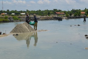 ABRASI. Penambang sedang menimbun pasir di Desa Lombang Kecamatan Giligenting. Warga setempat meresahkan penambang pasir liar karena pantai porak-poranda dan makam hancur.