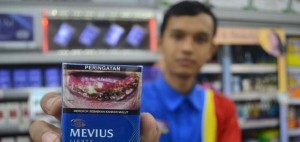 GAMBAR ROKOK. Pramuniaga menunjukan bungkus rokok bergambar di Jakarta beberapa waktu lalu. Pemerintah mewajibkan kepada produsen rokok menampilkan gambar "seram" dampak negatif merokok dalam kemasan rokok tersebut.