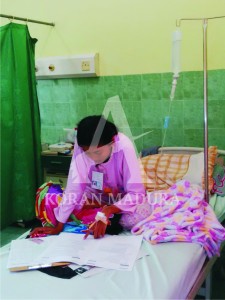 KONSENTRASI. Rahel Firda, salah seorang siswi SMP Plus Nurul Hikmah mengerjakan ujian nasional di RSUD dr Slamet Martodirdjo, Pamekasan, karena terserang DBD.