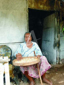Seorang nenek meratakan nasi aking yang hendak dijemur di depan rumahnya yang terbuat dari gedek. Dinas Sosial mengklaim program bantuan Rehabilitasi Sosial Perumahan Kumuh telah terealisasi 50 persen.