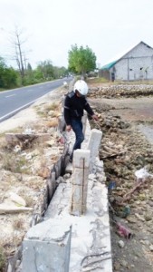 RUSAK. Salah seorang warga taddan ketika melihat kondisi tangkis laut yang mengalami ambruk di Jl Taddan, Kabupaten Sampang, Minggu (9/8).