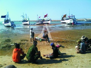 BENAHI PERALATAN. Sejumlah nelayan di Kecamatan Pamekasan sedang istirahat usai mengecat perahunya. Mereka tak berani melaut akibat cuaca buruk selama sepekan terakhir.
