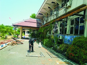 RENOVASI. Seorang warga mengamati perbaikan Gedung DPRD Pamekasan di Jl Kabupaten.