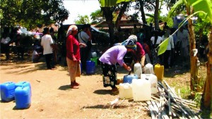KEMARAU. Masyarakat di pedesaan di Kabupaten Bangkalan saat menerima bantuan air bersih.