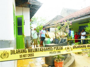 POLICE LINE. Keluarga dan tetangga korban pembantaian membersihkan darah di rumah korban di Kampung Pelar, Kelurahan Bangselok, Kecamatan Kota Sumenep, Kamis (22/10).