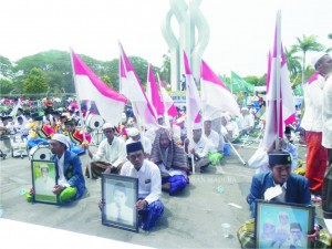 BERKIBAR. Peserta kirab dan Ikrar santri pada acara perayaan Hari Santri Nasional (HSN) mengebarkan bendera merah putih dan membawa gambar tokoh pendiri NU.