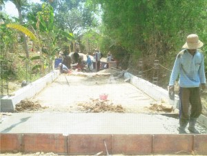 BETON. Sejumlah pekerja sedang mengecor plat injak pada oprit jembatan menggunakan pasir hitam. Pasir yang digunakan sudah ditimbun jauh hari sebelum kisruh di Lumajang yang menewaskan Salim Kancil.