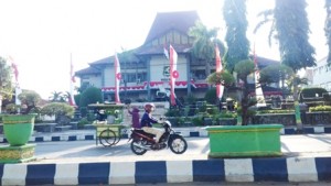 MELINTAS. Seorang penjual bakso melintas di depan Kantor DPRD Sumenep, Minggu (21/8).