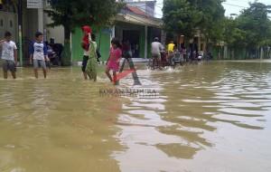 Anak-anak sedang bermain di genangan banjir di Jalan panglima Sudirman, Kelurahan Dalpenang. (MUHLIS)