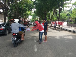 Taretan Dhibi' saat meminta sumbangan kepada pengendara roda dua. (ALI SYAHRONI)
