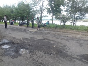 Koramil Saronggi bersama warga sedang gotong royong perbaiki jalan rusak. (FATHOL ALIF)